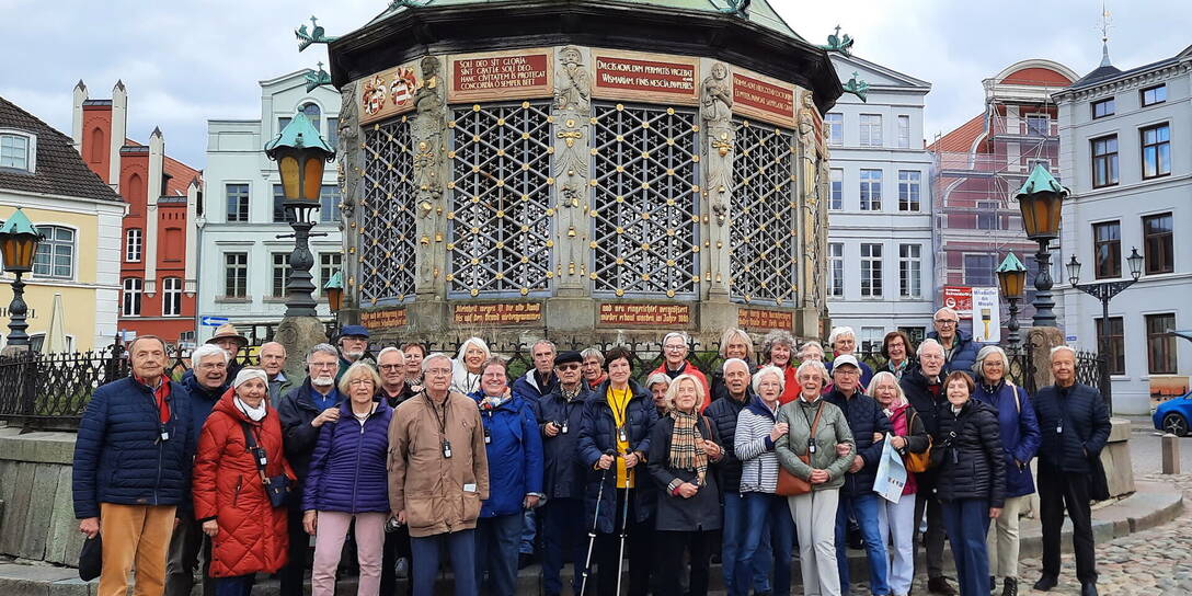 Reisegruppe vor der Wasserkunst auf dem Marktplatz in Wismar