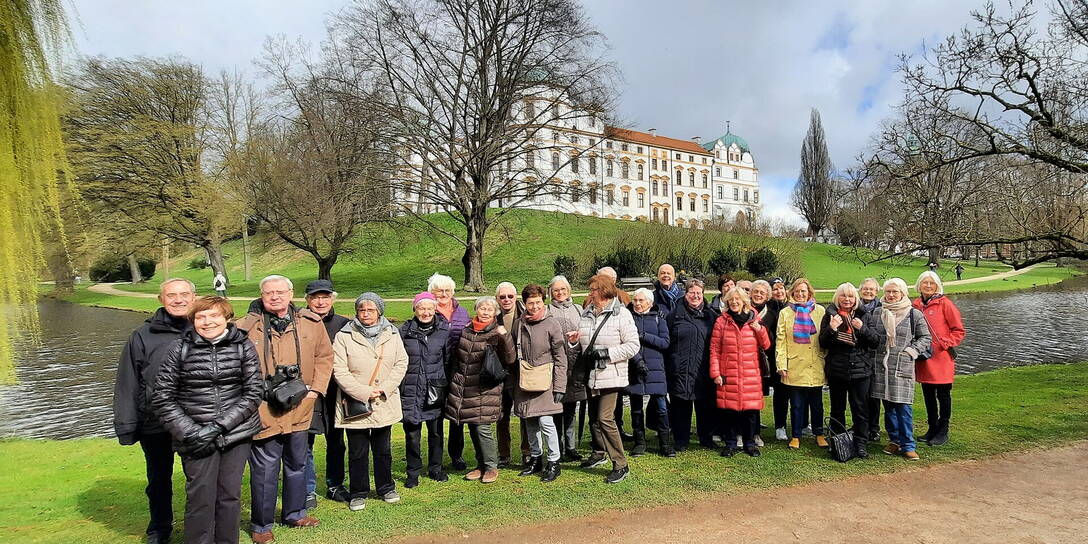Reisegruppe im Schlosspark vor dem Schloss Celle